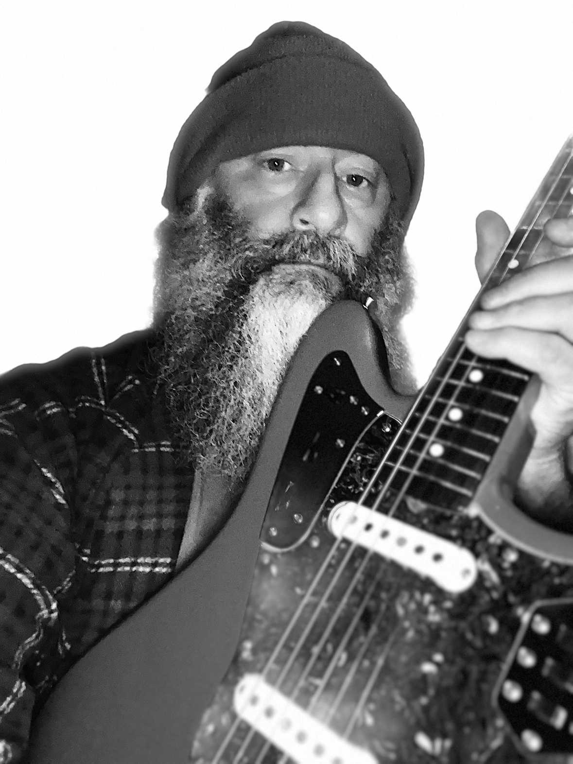 Black-and-white photo of Greg Wiggs wearing a beanie and holding an electric guitar